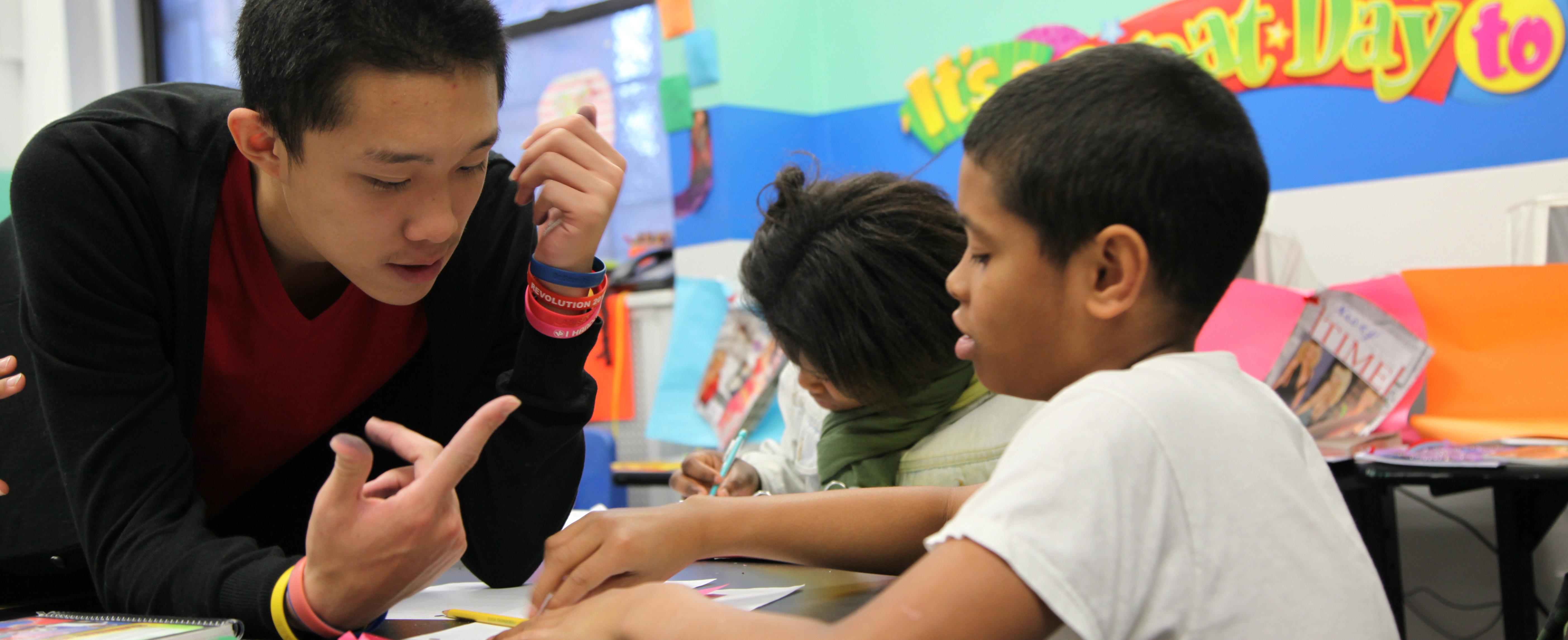 Young boy getting homework help from volunteer